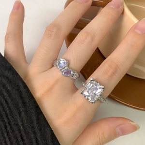 Lava texture silver rings set with square zircon and heart stone on woman's hand