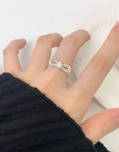 Silver bow knot double layer ring shown on hand with minimalist aesthetic and elegant style
