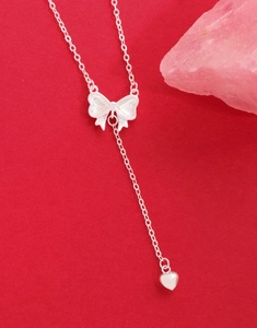 Detail of S925 sterling silver bow and heart pendant necklace with frosted texture