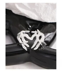 Dettaglio macro dell'anello a cuore in argento con texture fusa e finitura metallica