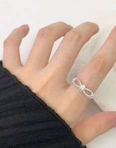 Close-up of S925 silver double-layered bow-knot ring worn on finger in a minimalist style