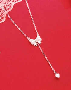 Close-up of S925 sterling silver bow necklace with a small solid heart-shaped pendant