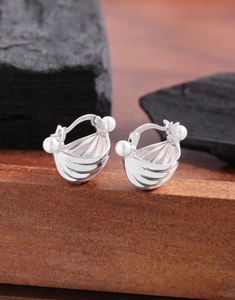 Macro shot of S925 sterling silver shell earrings with pearls on dark wood base