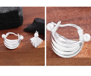Macro detail of S925 sterling silver stamp on elegant shell-shaped pearl earrings
