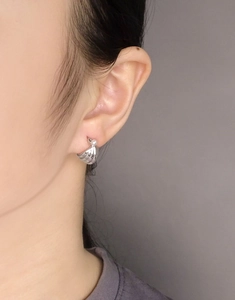 Macro shot of S925 silver shell earrings featuring radiating texture and white pearl detail