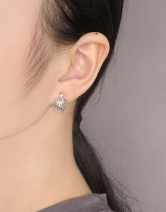 Detail of S925 silver shell earrings with white pearls shown on a model ear