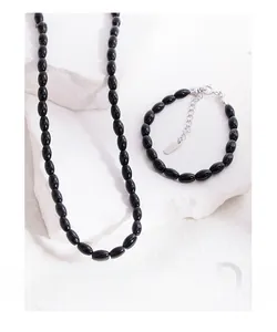 Macro detail of S925 sterling silver tag and black agate rice bead bracelet craftsmanship