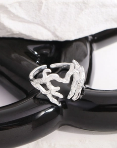 Vista macro di anello a cuore in argento S925 con trama lava su supporto nero