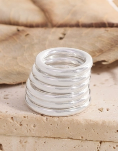 Makroaufnahme von sieben polierten S925 Sterling Silber Ringen auf einem Naturstein
