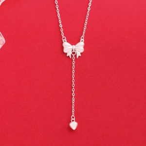 Elegant S925 sterling silver bow and heart pendant Y-necklace for women on red background