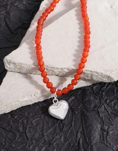 Vue détaillée du collier en perles d'agate rouge avec pendentif coeur en argent