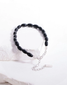Close-up of S925 sterling silver stamp on black onyx beaded bracelet with lobster clasp