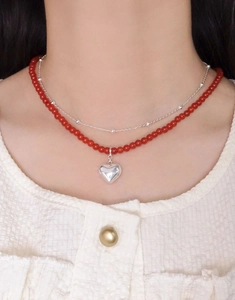 Détail d'un collier double rang en argent S925 avec perles d'agate rouge et cœur