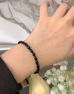 Detail of S925 silver bracelet with oval black onyx beads worn on a female wrist