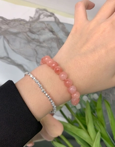 Detail of layered S925 silver beaded bracelet and natural pink agate beads on wrist
