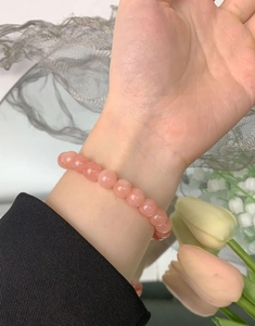 Close-up of a pink natural agate beaded bracelet on a wrist with silver accents