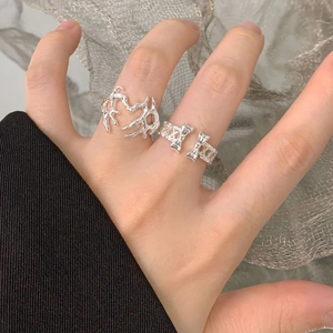 Set di anelli in argento S925 con cuore a trama lavica e fiocco sulla mano di una modella