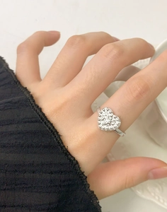 Detail shot of a S925 silver heart ring with micro-set white crystals on a woman's hand