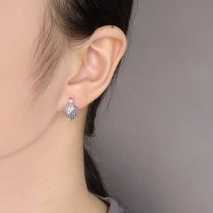 Elegant S925 sterling silver shell earrings with pearl accent worn by a model