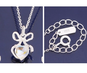 Macro detail of S925 sterling silver necklace showing bow pendant and hallmark tag