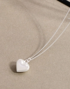 Close-up of a 3D puffed heart pendant on a delicate S925 sterling silver chain
