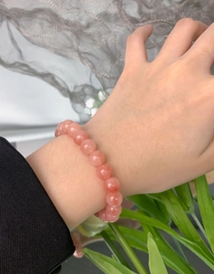 Detailed view of natural pink agate beaded bracelet on a woman wrist showing smooth texture