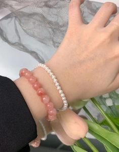 Detail of S925 silver pink agate beaded bracelet and dainty pearl layered on wrist