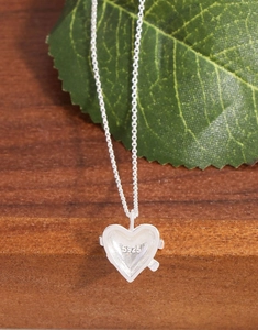 Vue macro du poinçon S925 sur le pendentif cœur argent avec relief nœud
