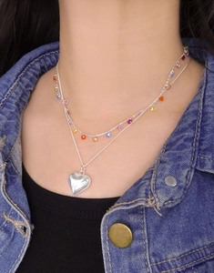 Close-up of double-layer S925 silver heart necklace with colorful beads on denim jacket