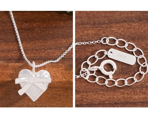 Macro de collier en argent S925 avec pendentif cœur et détail de nœud en ruban 3D