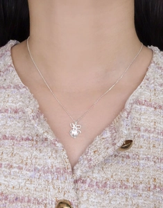 Close-up of S925 silver heart and bow pendant necklace worn by a female model