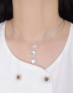Détail du collier triple rang en argent S925 avec nœud et pendentif gemme bleue