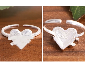 Macro detail of S925 sterling silver heart ring with bow knot and adjustable band