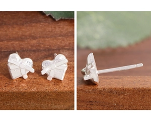 Vue macro de boucles d'oreilles cœur en argent S925 avec nœud en relief et poinçon