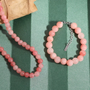 Pink agate beaded bracelet and necklace set in S925 sterling silver on green backdrop