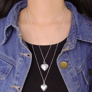 Double-layered S925 silver necklace with polished heart pendants on casual outfit