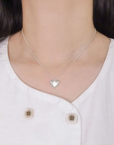 Gros plan du collier avec pendentif cœur en argent S925 et relief sur le mannequin
