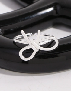 Vue macro d'une bague nœud en argent sterling S925 poli avec design ouvert ajustable