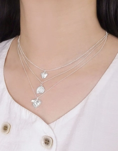 Détail du collier triple rang en argent S925 avec pendentifs cœur et coquillage nautile