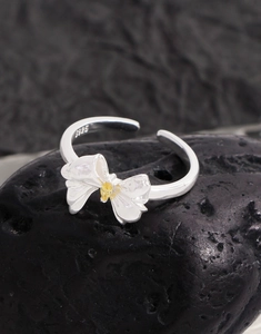 Macro shot of S925 sterling silver bow ring with yellow crystal on black stone