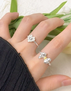 Detail of S925 silver bow ring with marquise zircon and heart shape on a finger