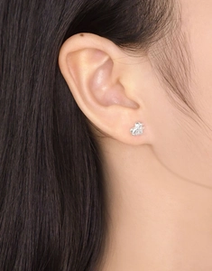 Gros plan de boucles d'oreilles cœur en argent sterling S925 portées à l'oreille