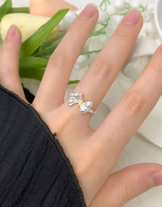 Close-up of S925 sterling silver bow ring with yellow zircon on a finger