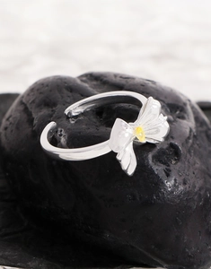 Close-up of S925 silver bow ring with marquise yellow zircon on black rock