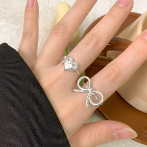Elegant S925 sterling silver bow and heart rings set shown on a hand in a soft setting