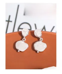 Macro shot of silver S925 earrings with irregular hammered texture and metallic luster