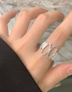 Macro shot of minimalist S925 sterling silver irregular wavy ring on model hand