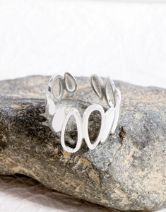 Detailed view of S925 sterling silver irregular open ring on a natural stone base