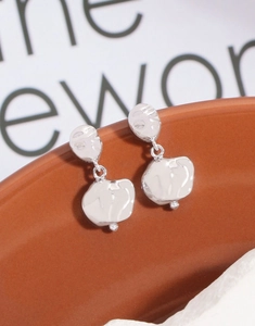 Macro detail of silver S925 irregular meteorite earrings with hammered metal texture