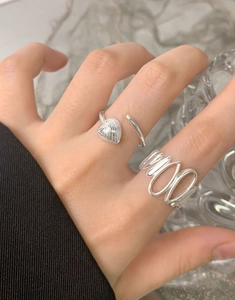 Detail of S925 silver irregular wave and heart shell rings on model hand